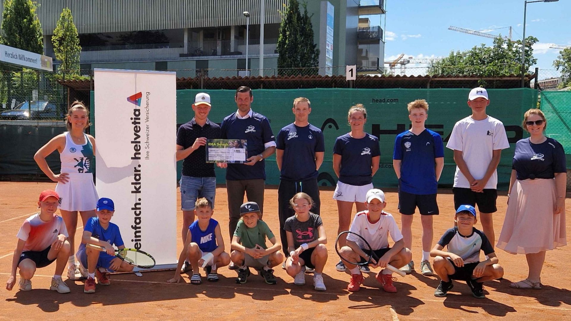 V.l.n.r.: Marlene Ostermann und Michael Egger (Helvetia) bei der Scheckübergabe mit Martin Rappold, Christoph Steinlechner, Sigrid Weller, Susanne Königshofer vom Uhrturmtrophy SV und den jungen Tennisspielenden ©Uhrturmtrophy SV