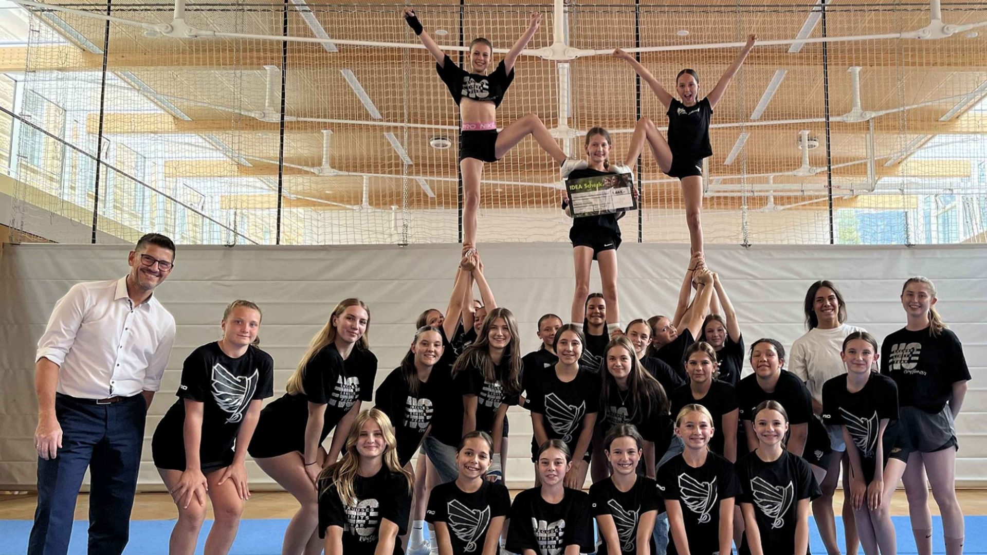 Matthias Ruetz (l.), Patricia Platzgummer (2.v.r) und Lena Angerer (r.) mit den Sportler:innen der Raiderettes Cheerleader ©Helvetia